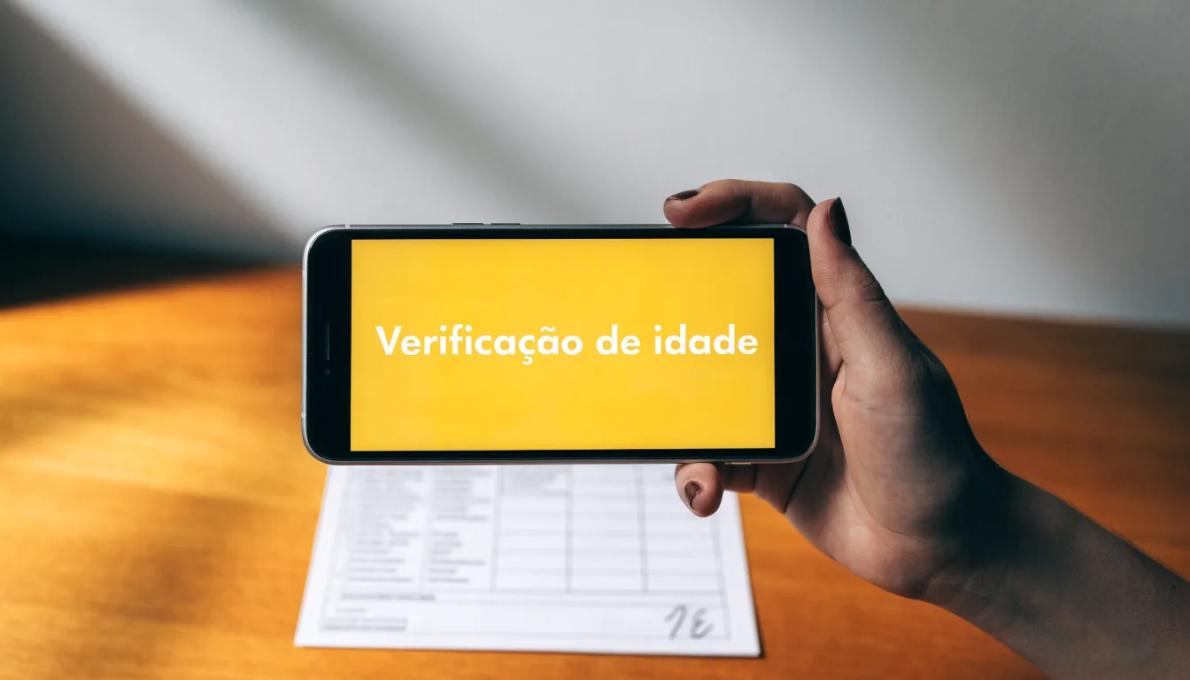 Uma folha de licença em papel com um selo vermelho, pousada numa secretária de madeira ao lado de uma caneta